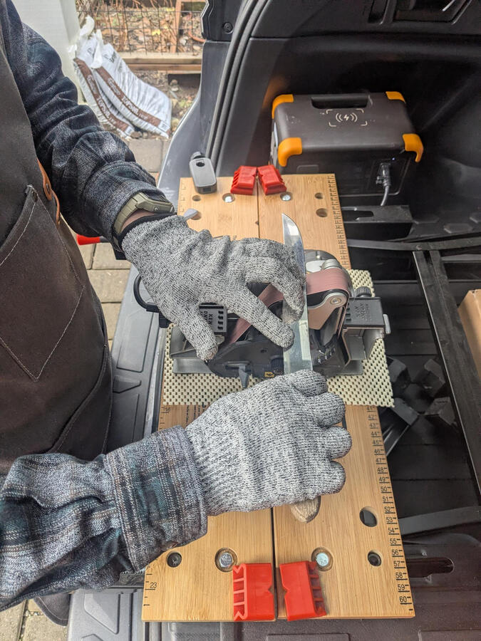 Close-up shot of sharpening a knife with a belt grinder