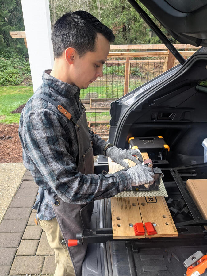 Man sharpening knife on belt grinder Man sharpening knife on belt grinder